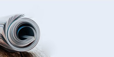 Gerolltes Magazin auf Holz vor blauem Hintergrund